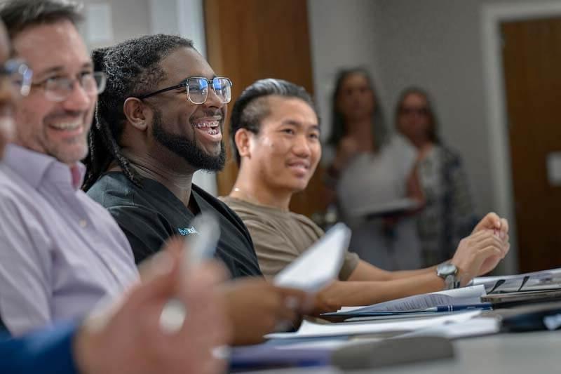 Smiling students around table in seminary classroom